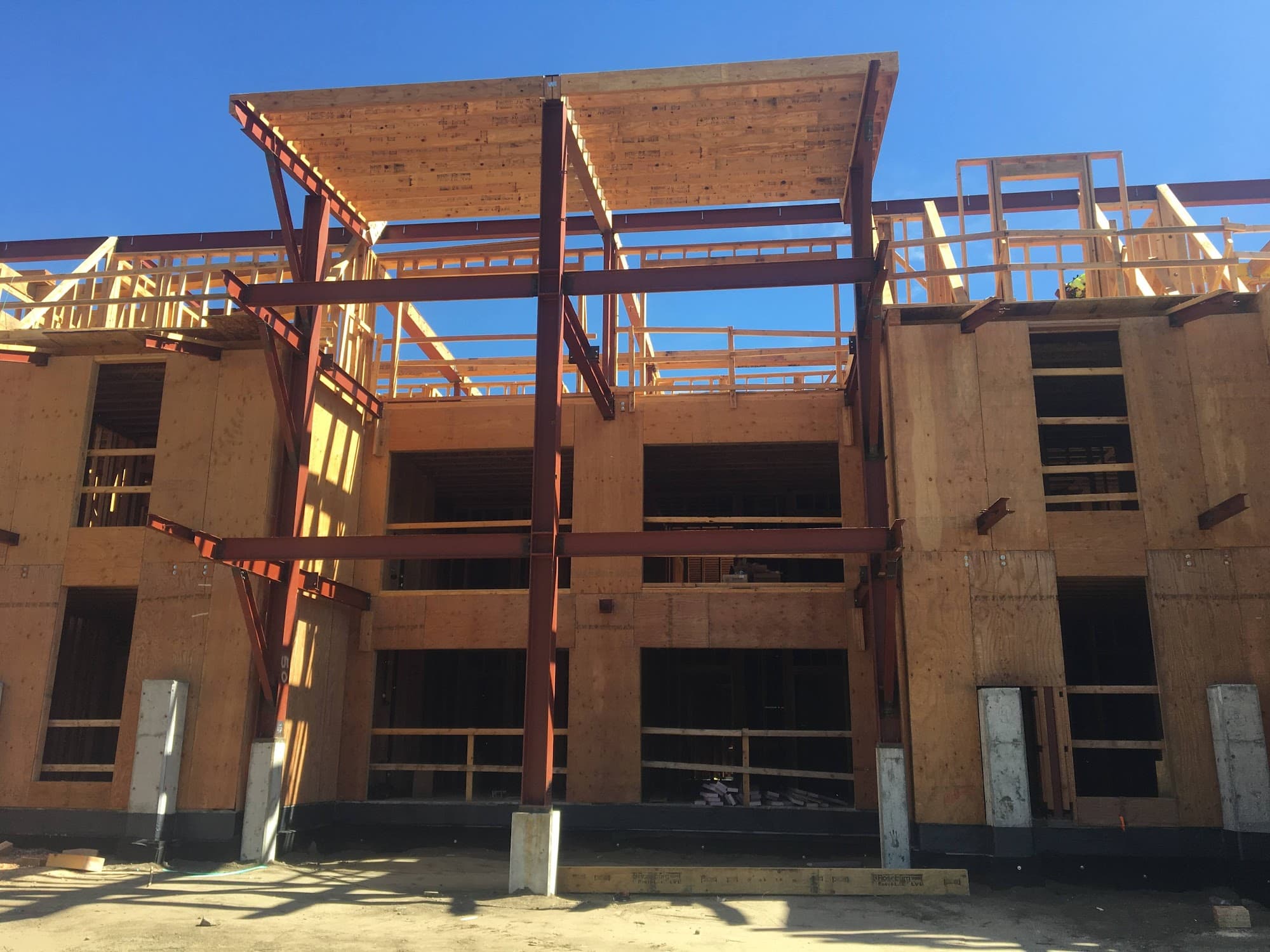 Multi-story wood-frame building with red steel moment frames — Palisade Engineering commercial structural engineering