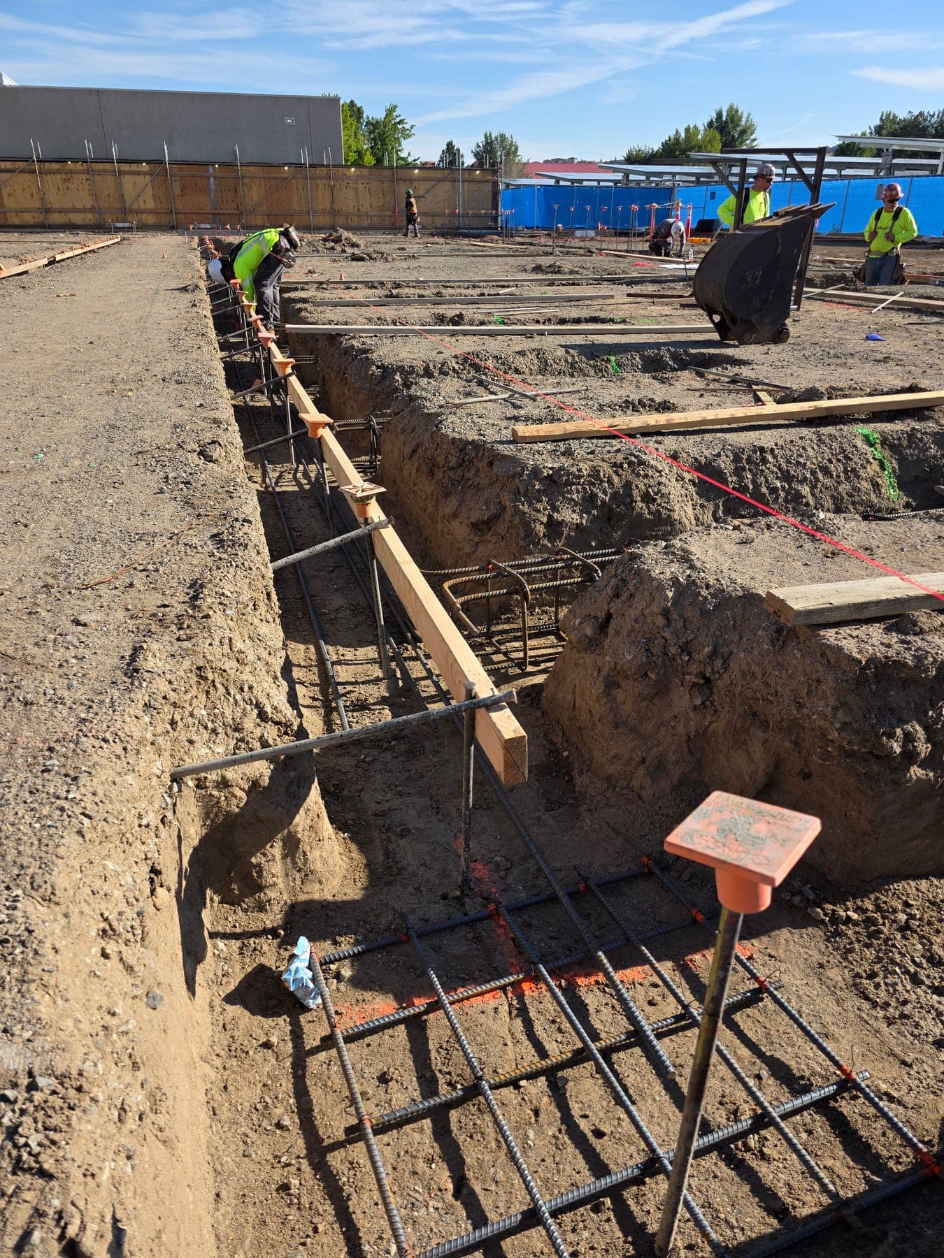 Footing excavation with reinforcing steel and anchor rods set before the concrete pour